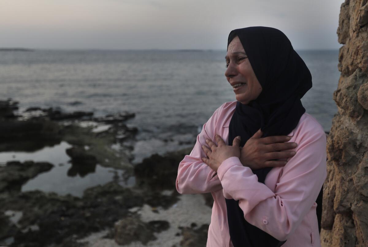 A woman cries and prays her son's safe return.