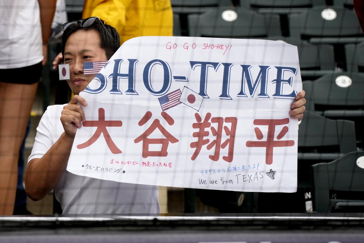 A fan of Shohei Ohtani watches during batting practice prior to the MLB All-Star game.