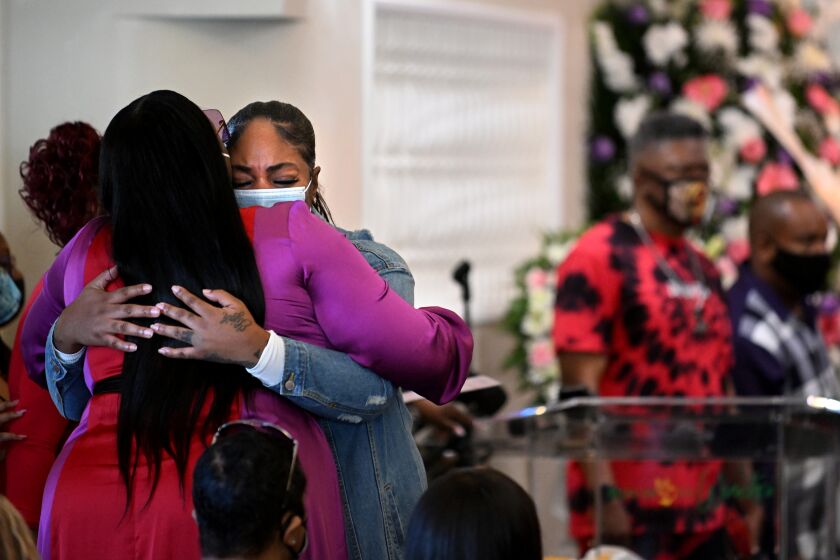 Inglewood, California January 27, 2022: Mourners hug at funeral services for 16-year-old Tioni Theus in Los Angeles Thursday. The body of Theus was found near the 110 freeway with a gun shot wound in the neck. (Wally Skalij/Los Angeles Times)