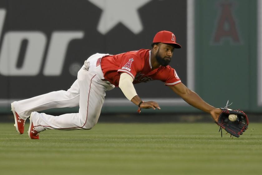 ANAHEIM, CA - APRIL 10: Brian Goodwin #18 of the Los Angeles Angels of Anaheim dives for a ball hit by Lorenzo Cain #6 of the Milwaukee Brewers catching it on one hop allowing a base hit in the first inning at Angel Stadium of Anaheim on April 10, 2019 in Anaheim, California. (Photo by John McCoy/Getty Images) ** OUTS - ELSENT, FPG, CM - OUTS * NM, PH, VA if sourced by CT, LA or MoD **