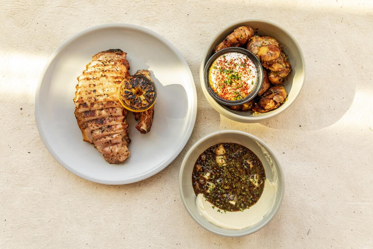 Pork chops with sides of lentil and potatoes from Otium restaurant.