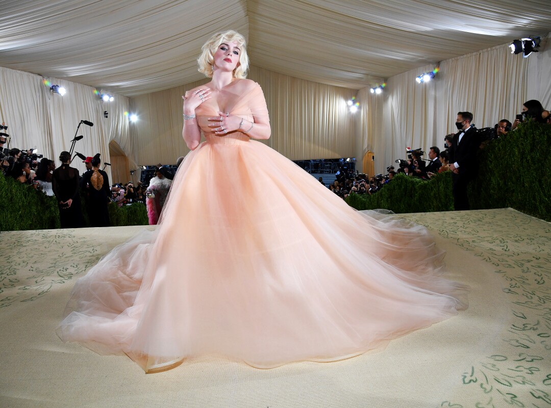 A woman wears a peach-colored ball gown