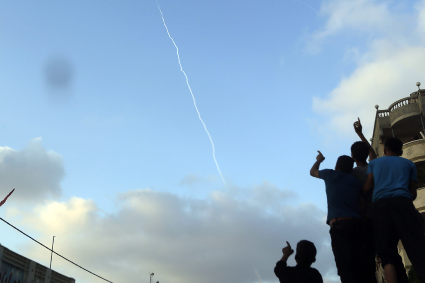 Palestinians at the funeral of a child killed in a Gaza explosion point to the smoke trail of a missile fired by militants from inside northern Gaza Strip on July 28.