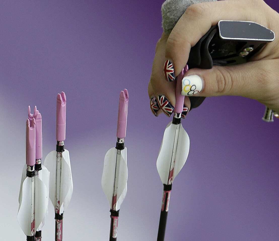 Britain's Amy Oliver grabs an arrow from her quiver with her nails painted in her country's colors during an elimination round of the individual archery competition.