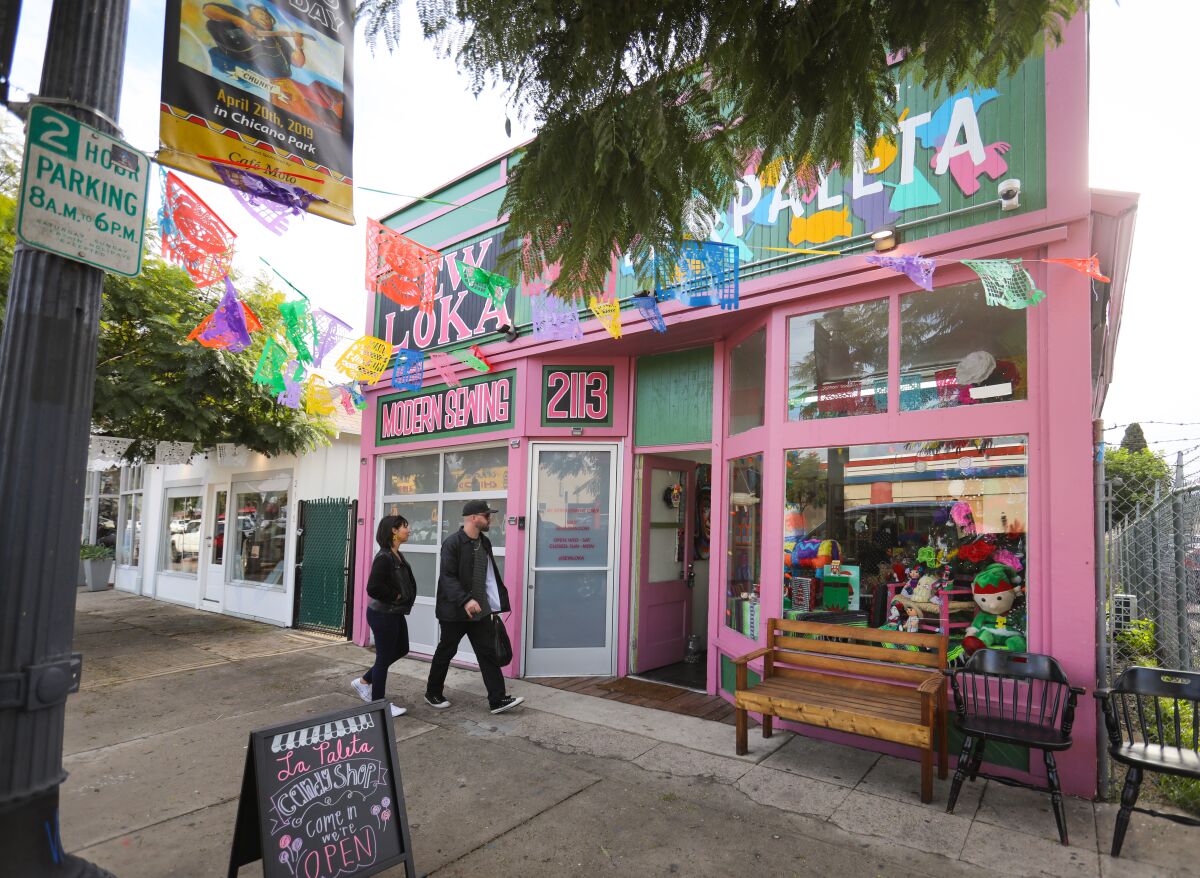 Pink shop in Barrio Logan with two people walking toward the door.