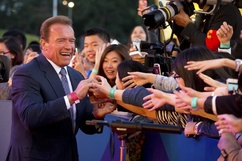 Arnold Schwarzenegger shakes hands with Chinese fans as he arrives April 16 for the grand opening of the fifth annual Beijing International Film Festival.