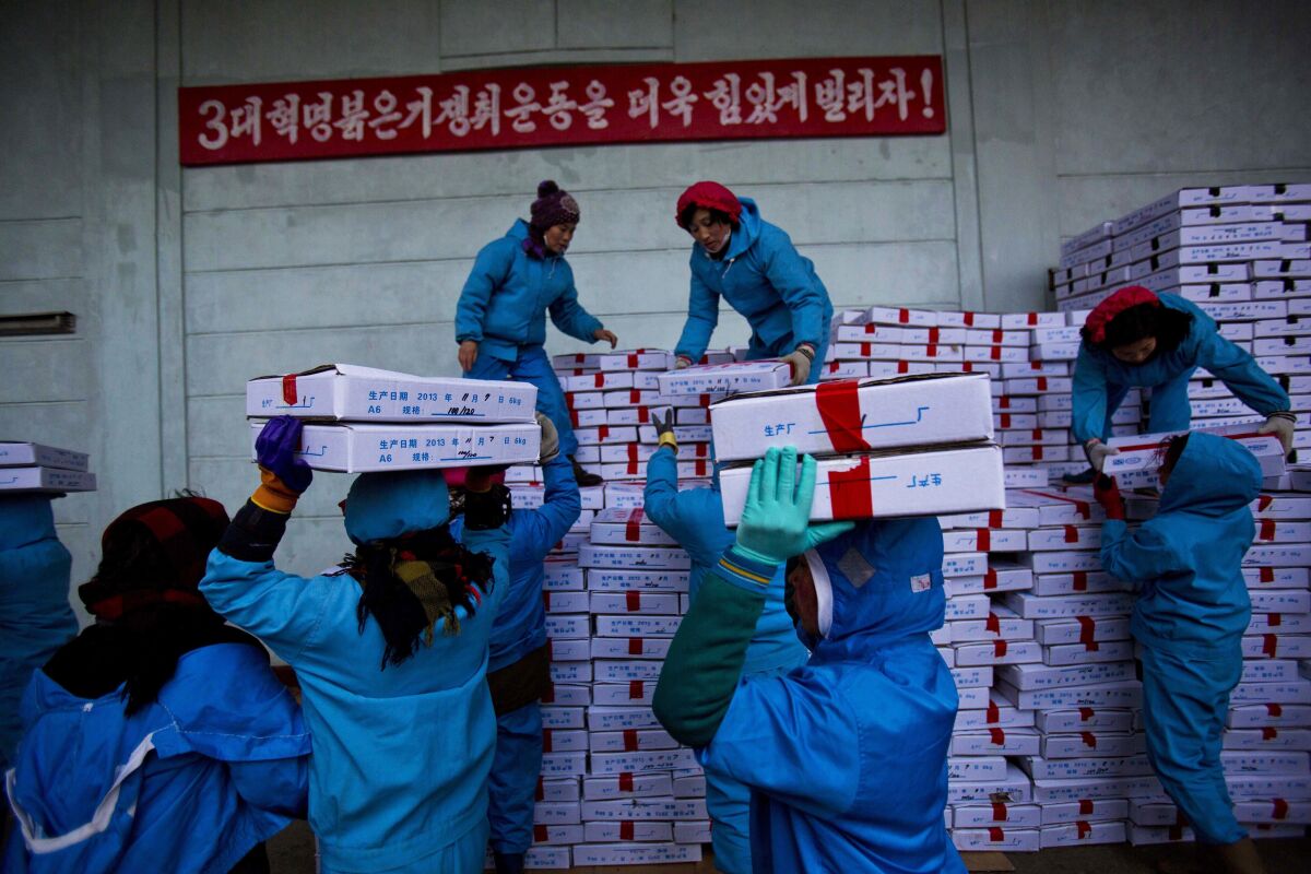 FILE - Workers carry boxes of seafood on Nov. 8, 2013, as they load a Chinese transport truck at the Suchae Bong Corp seafood factory in Rajin, North Korea, inside the Rason Special Economic Zone. China and Russia are urging the U.N. Security Council to end a host of sanctions against North Korea ranging from the export of seafood and textiles to the cap on imports of refined petroleum products and the ban on its citizens working overseas and sending home their earnings. (AP Photo/David Guttenfelder, File)