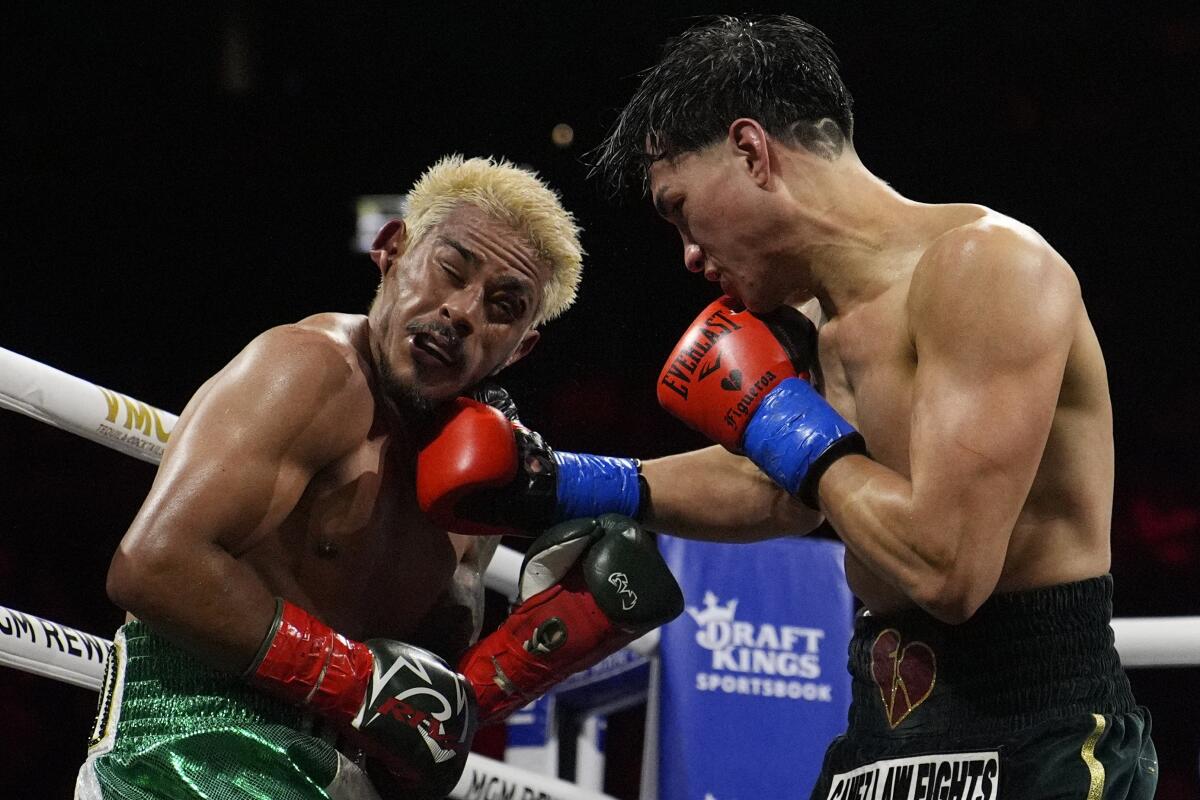 Brandon Figueroa, right, punches Jessie Magdaleno during their WBO featherweight title fight Saturday.