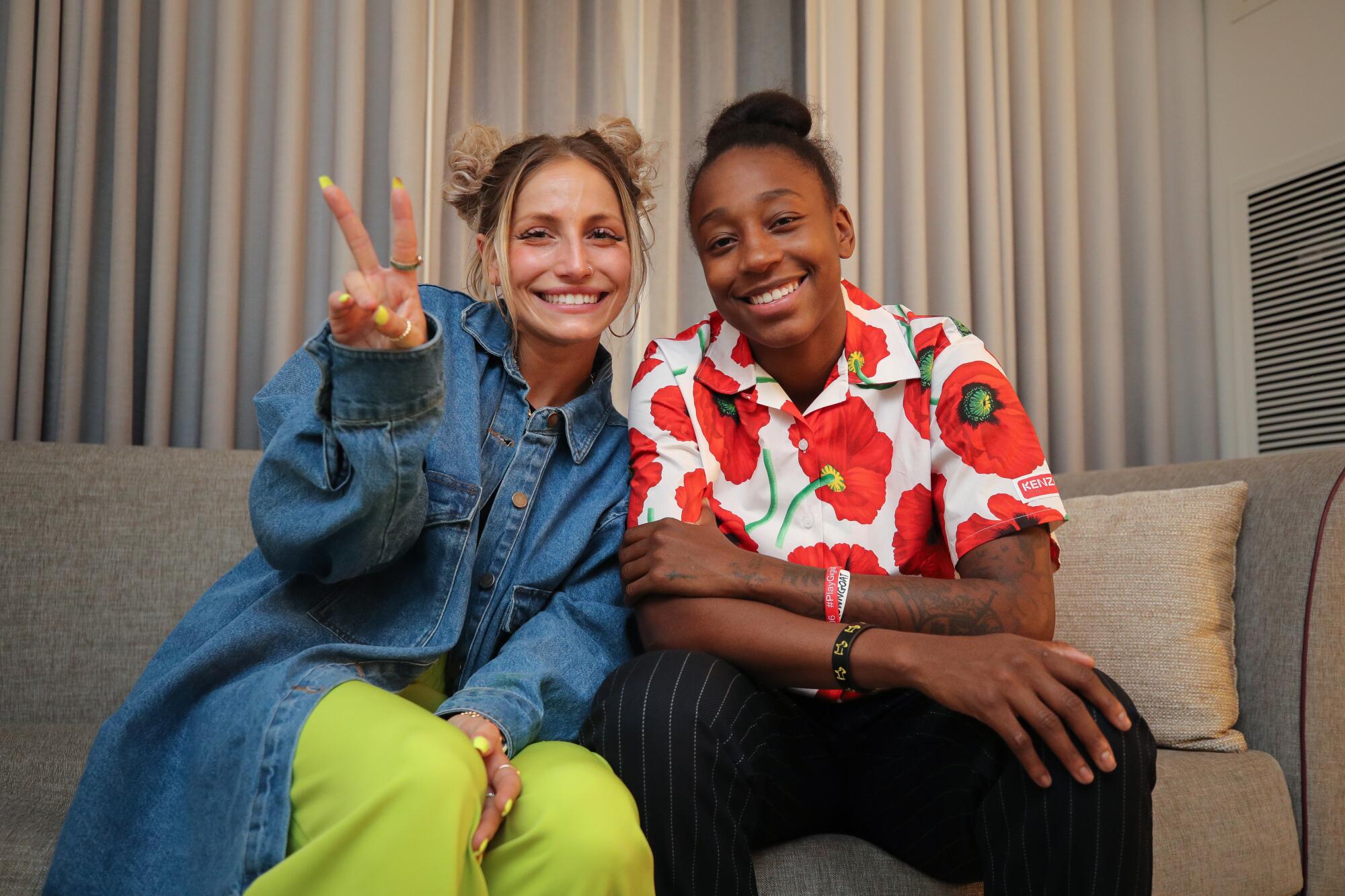 Stylist Sydney Bordonaro gives the peace sign as she poses for a photo with WNBA star Jewell Loyd pose for a photo.