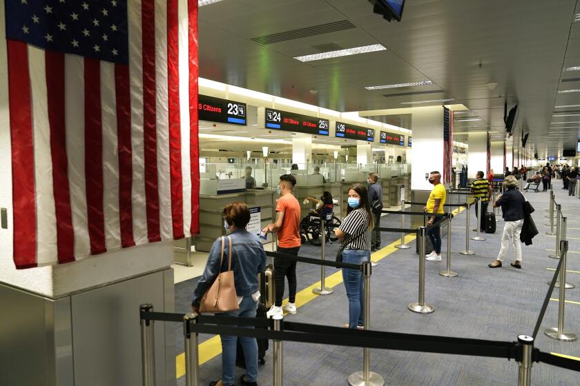 Pasajeros de vuelos internacionales llegan al Aeropuerto Internacional de Miami, donde son sometidos a revisiones minuciosas de parte de personal de la Oficina de Aduanas y Protección Fronteriza de Estados Unidos (CBP por sus iniciales en inglés), el viernes 20 de noviembre de 2020, en Miami. (AP Foto/Lynne Sladky)