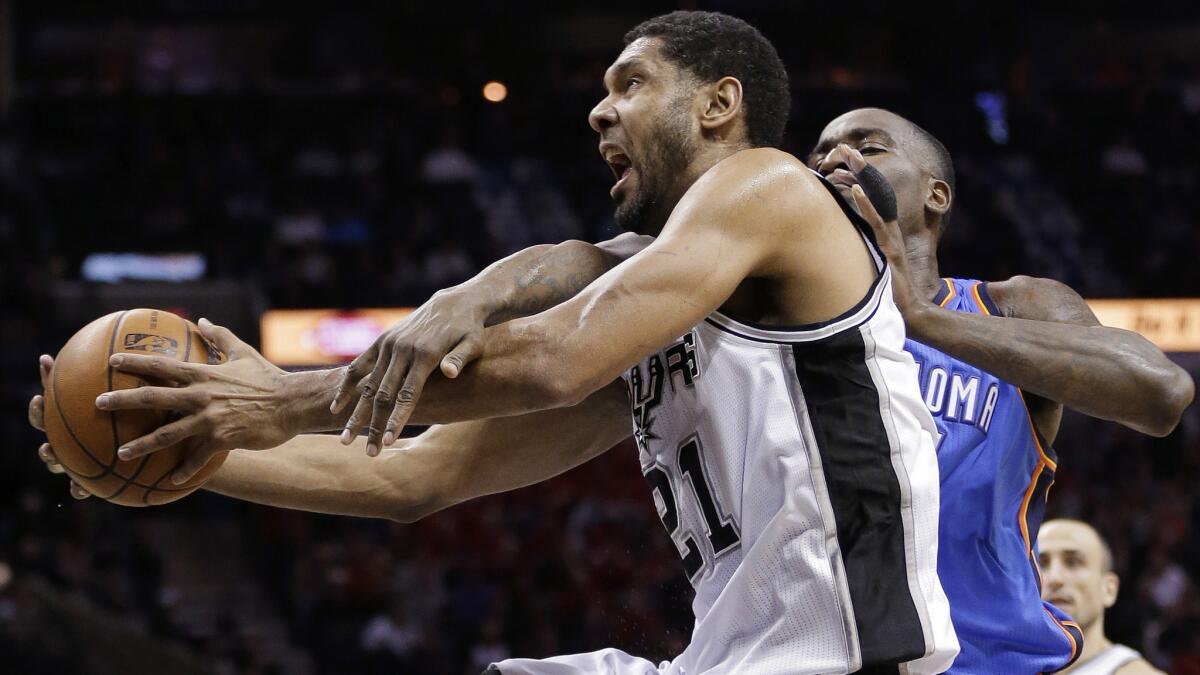 San Antonio Spurs forward Tim Duncan, left, is fouled by Oklahoma City Thunder's Kendrick Perkins while driving to the basket during a game in January. Who will win the Western Conference finals matchup between San Antonio and Oklahoma City?