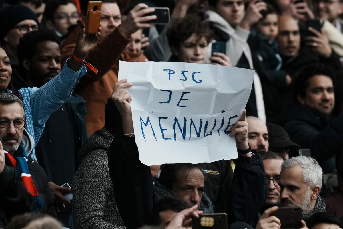 Un aficionado con un cartel con la frase 'PSG Je mennuie' ('PSG Estoy Aburrido') 