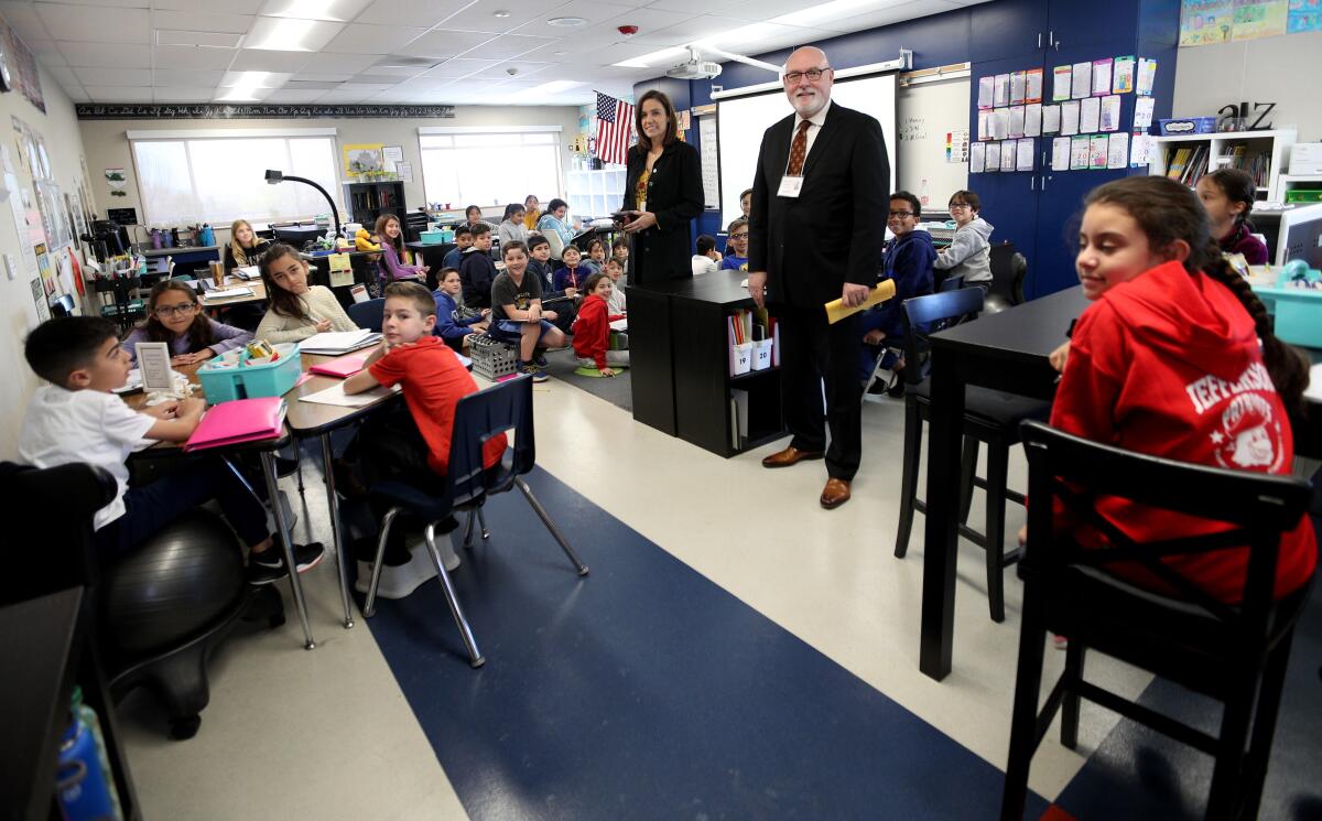 Ward Smith, manager of Bluespace Interiors, standing center right, and principal Sandra De Barros, center left, talk to students at Jefferson Elementary School during this year's Principal for a Day event on Thursday.