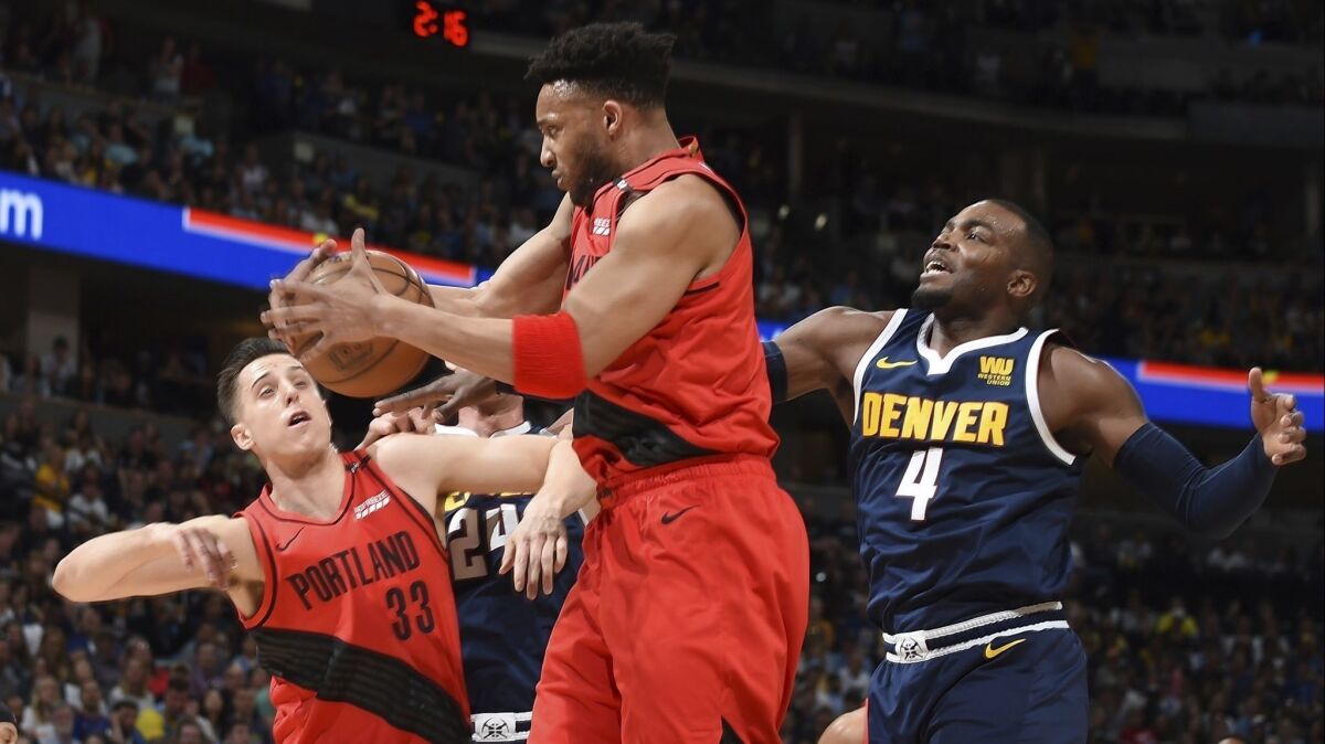 Portland Trail Blazers guard Evan Turner, center, pulls in a rebound in front of Denver Nuggets forward Paul Millsap during Game 7 of the NBA Western Conference semifinals on May 12.