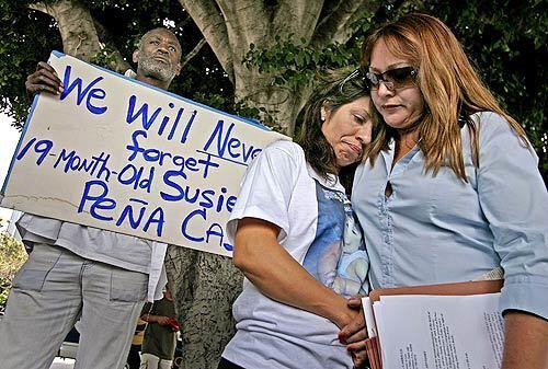 Two years ago, 19-month-old Susie Peña lost her life as the innocent victim in a shootout between police and her father. On Tuesday, her tearful mother Lorena Lopez, above center, was comforted by Arcy Carranza at a news conference in downtown L.A. where Lopez called for the resignation of Police Chief William J. Bratton. A man who said his name was Big Money Griff holds a sign expressing a heartfelt sentiment.