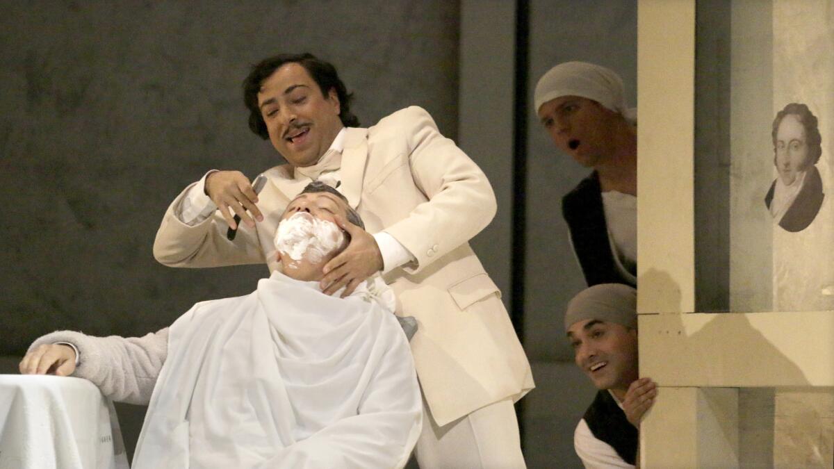 Alessandro Corbelli as Doctor Bartolo (being shaved) and Rodion Pogossov as Figaro in Los Angeles Opera's "The Barber of Seville" at Dorothy Chandler Pavilion in Los Angeles.