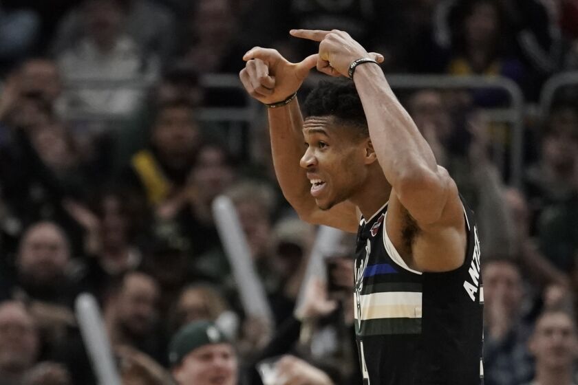 Milwaukee Bucks' Giannis Antetokounmpo reacts after making a three-point basket during the second half of an NBA basketball game against the Los Angeles Lakers Thursday, Dec. 19, 2019, in Milwaukee. The Bucks won 111-104. (AP Photo/Morry Gash)