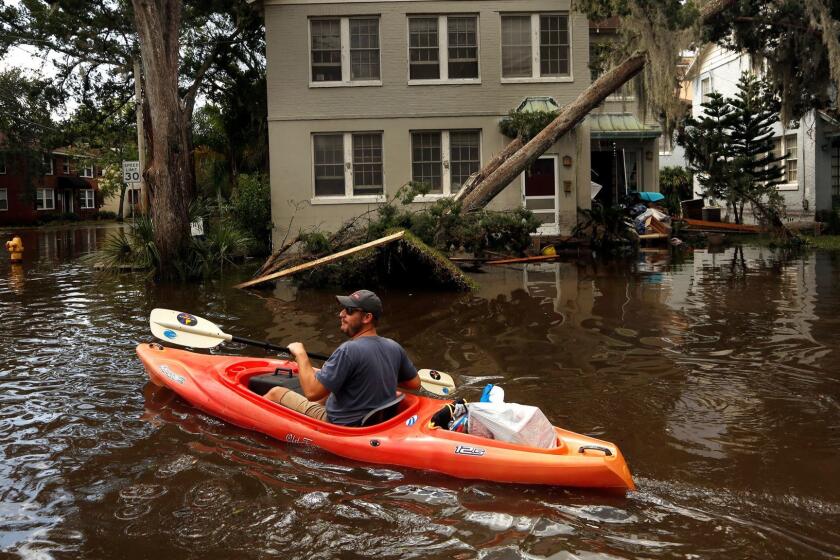 JACKSONVILLE, FLORIDA--SEPT. 12, 2017--In the San Marco area of Jacksonville, FL, Joshua Young takes some of his personal belonging out by kayak after flooding hit his apartment building. In Jacksonville, Florida, water levels caused by river surge and Hurricane Irma lead to some of the worst flooding the city has seen in decades. (Carolyn Cole/Los Angeles Times)