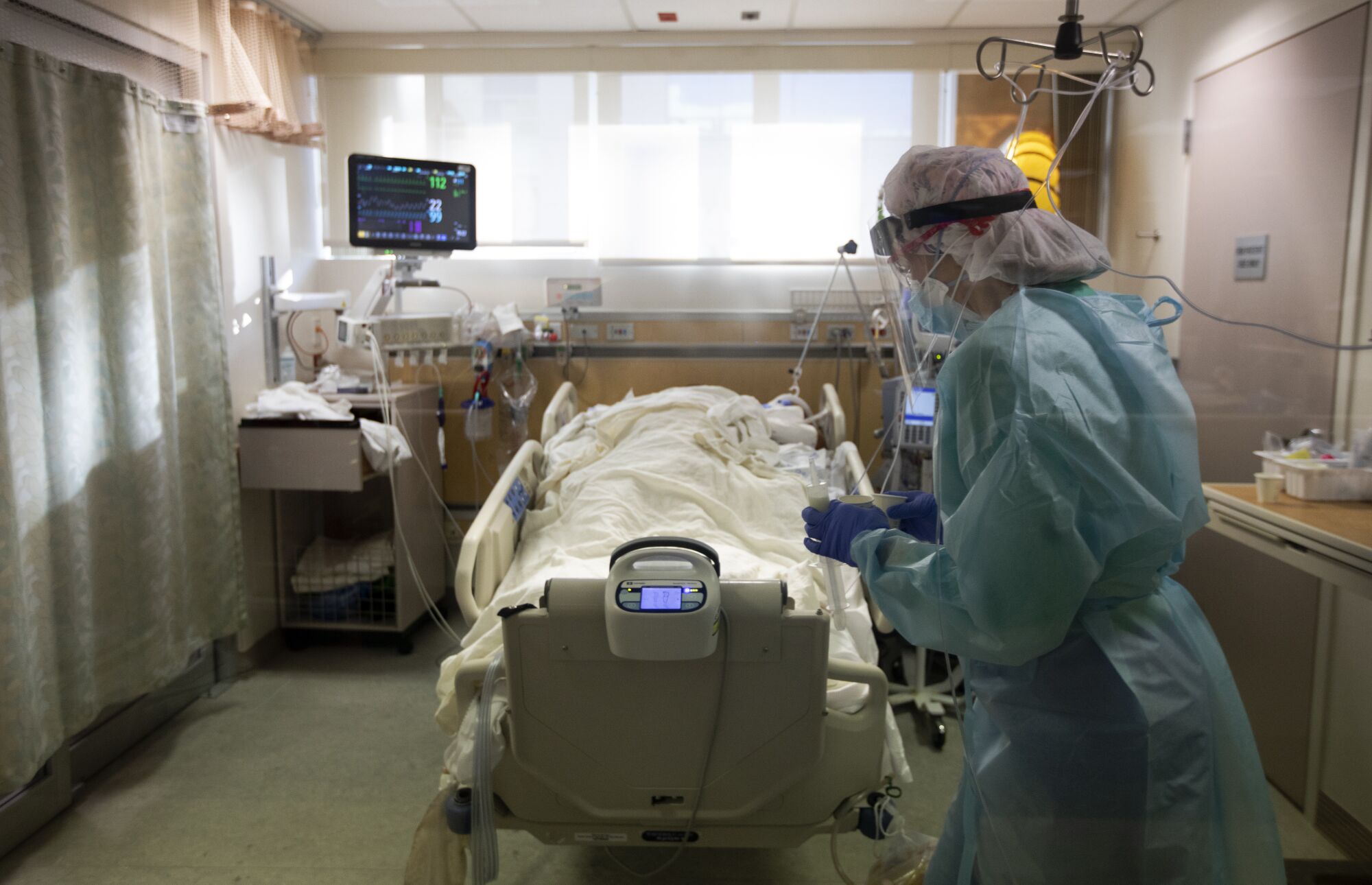 RN Joan Pung weaves her way through IV lines as she brings medication