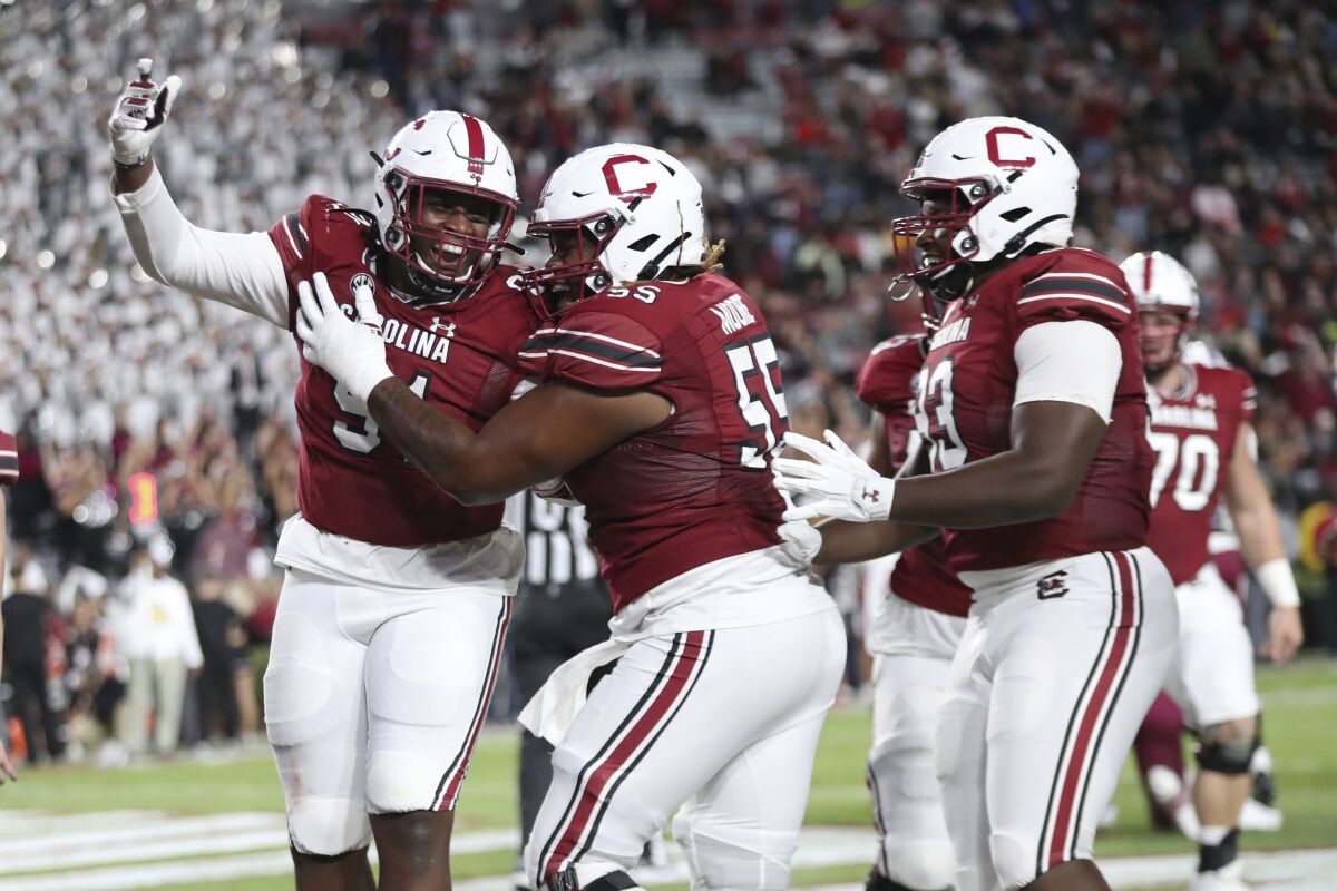 South Carolina's Tonka Hemingway (91) celebrates with Jakai Moore (55) after rushing for a 2-point conversion during the first half of the team's NCAA college football game against South Carolina State on Thursday, Sept. 29, 2022, in Columbia, S.C. (AP Photo/Artie Walker Jr.)