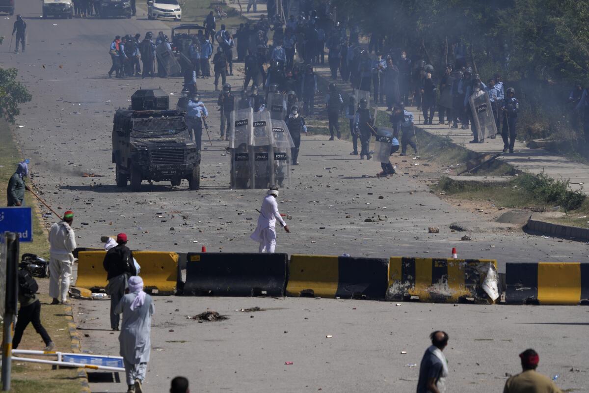 Police officers and protesters exchange stones during clashes.
