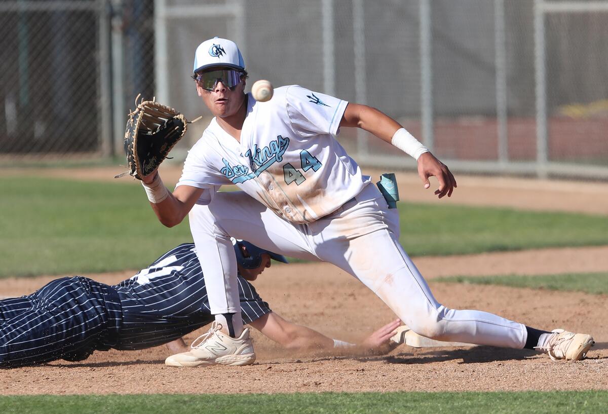 Carter Danz (44) of Corona del Mar eyes a quick throw on a pick-off attempt at first base during Wednesday's game.