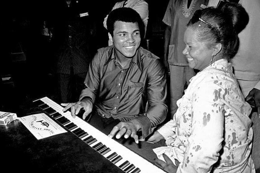 Muhammad Ali chats with Etta James at the piano at the Kinshasa Hotel in Zaire in September 1974. James and other African American musicians were in the country to perform at the Zaire 74 music festival. The concert was organized as a promotional event to coincide with the heavyweight championship boxing match between Ali and George Foreman.
