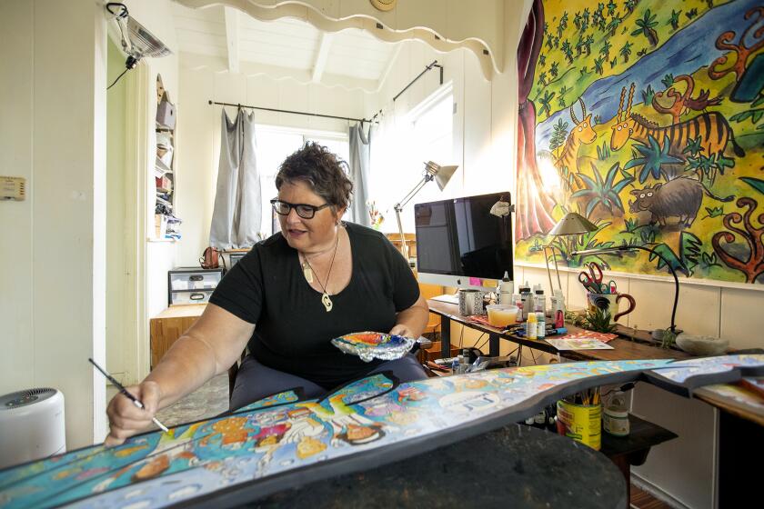Bonnie Matthews, a Costa Mesa artist and children's books illustrator, paints a baby whale cut out at her apartment in Costa Mesa on Monday, March 28. Matthews is working with the Mesa Water District on an project that will be displayed at John Wayne Airport in honor of Earth Month in April.