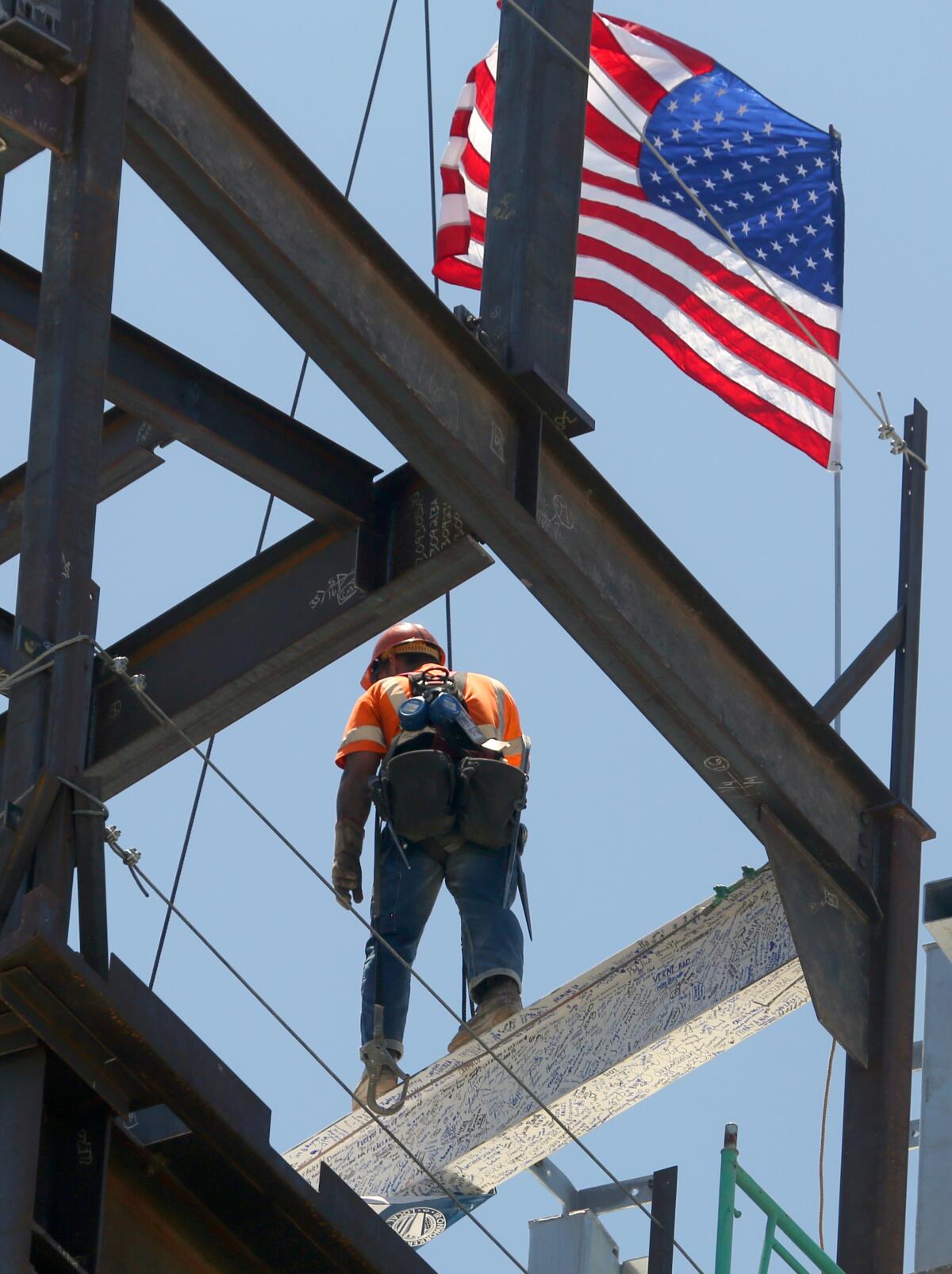 A construction worker Thursday oversees the installation of a beam in what will be a UCI Health-operated hospital in Irvine.