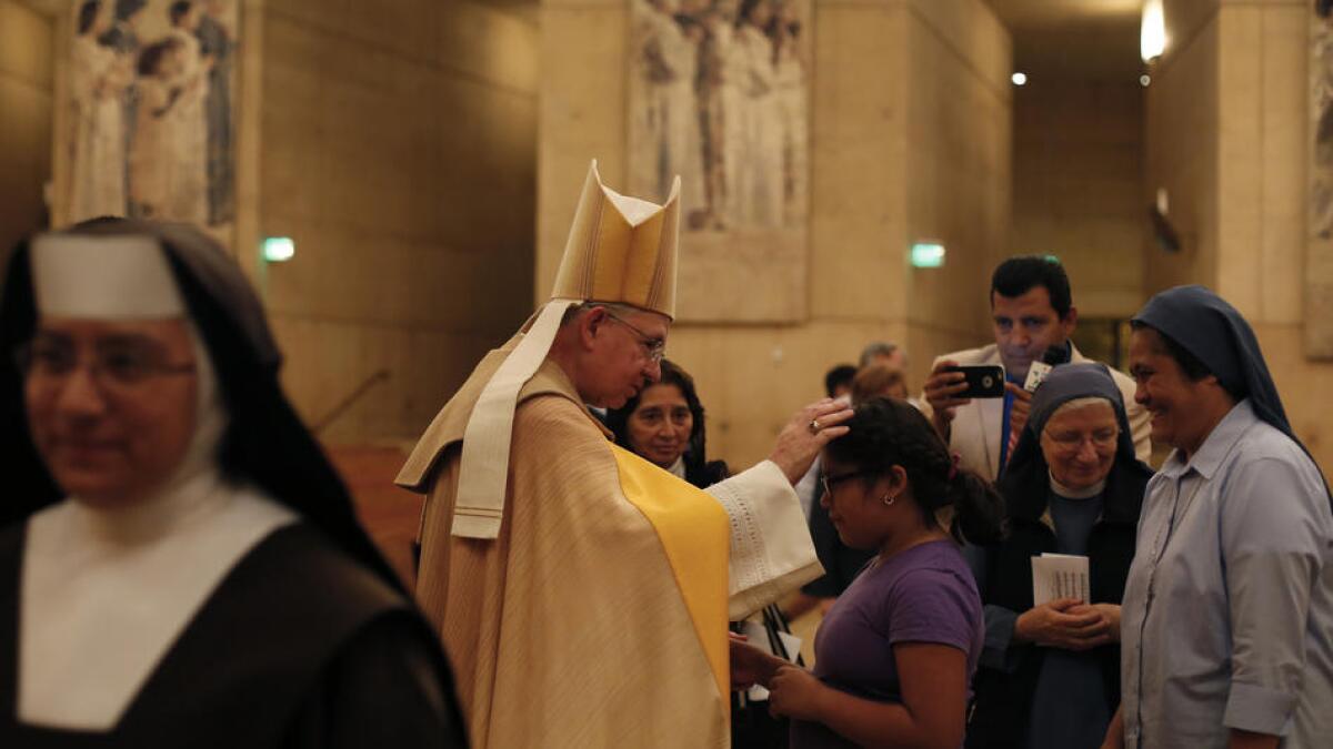 Archbishop José H. Gomez greets Jade Lopez, 9, of Los Angeles during an interfaith prayer service at the Cathedral of Our Lady of the Angeles.