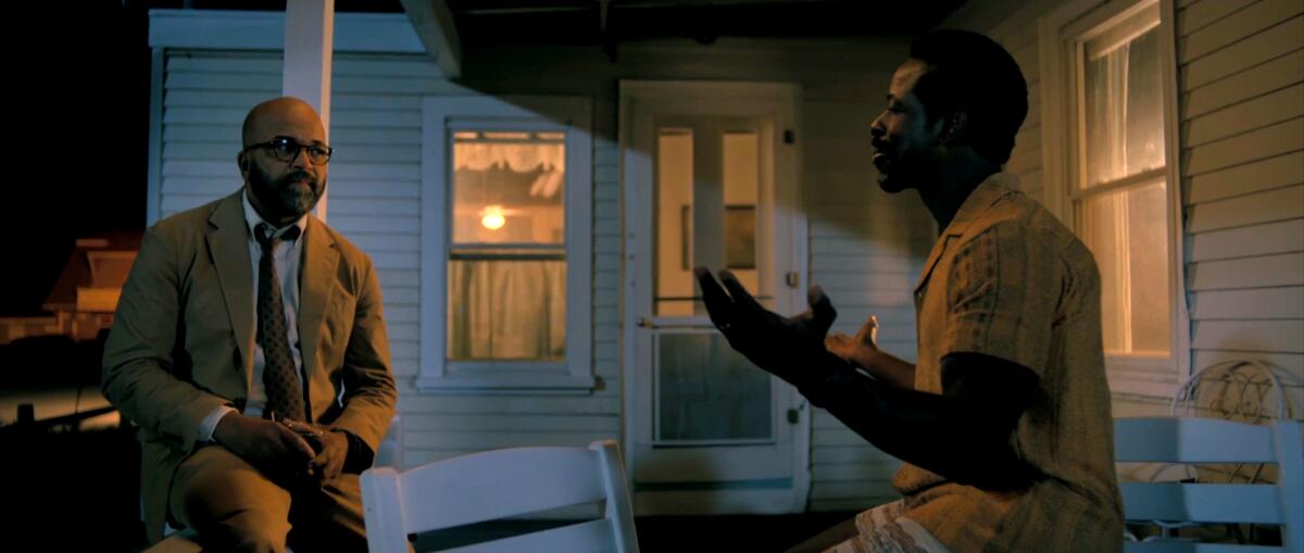 Two men talk on a porch at night in "American Fiction."