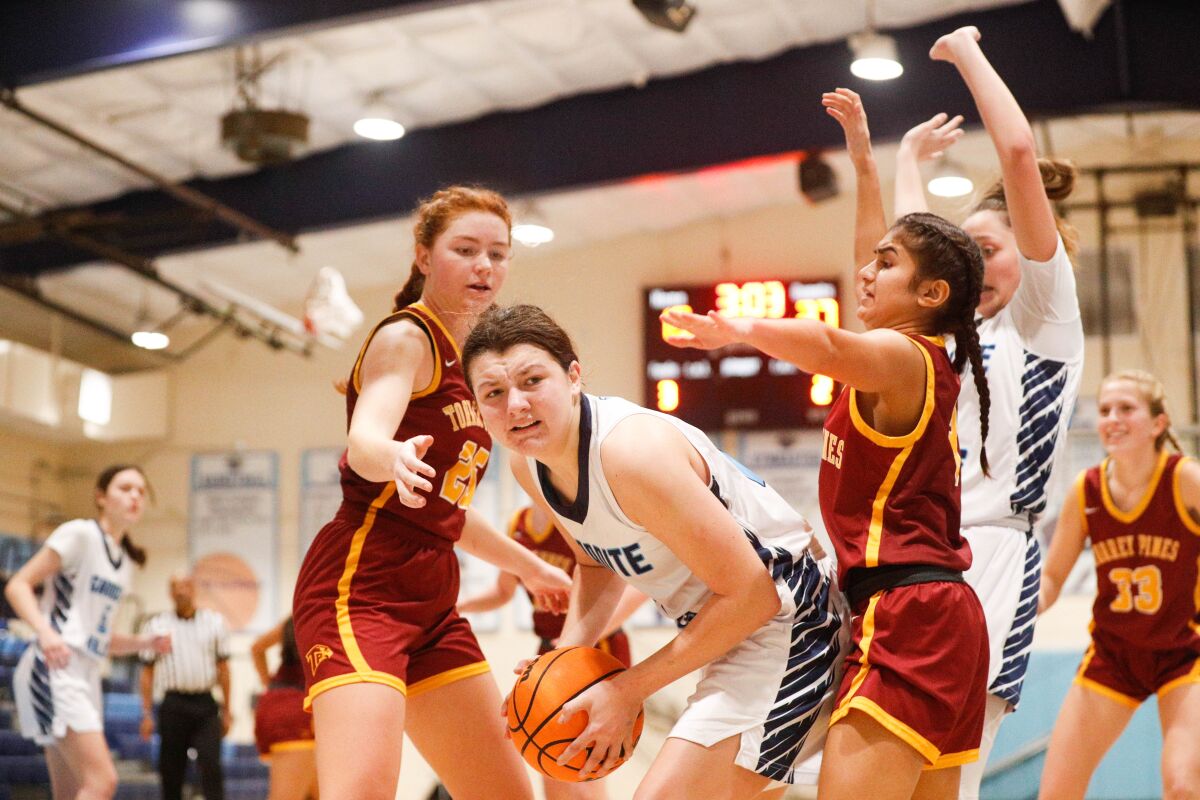 Granite Hills' Khaley Kaesser (12) grabs the rebound but is hounded by Torrey Pines Laura Rucks (left) and Roma Panchal.