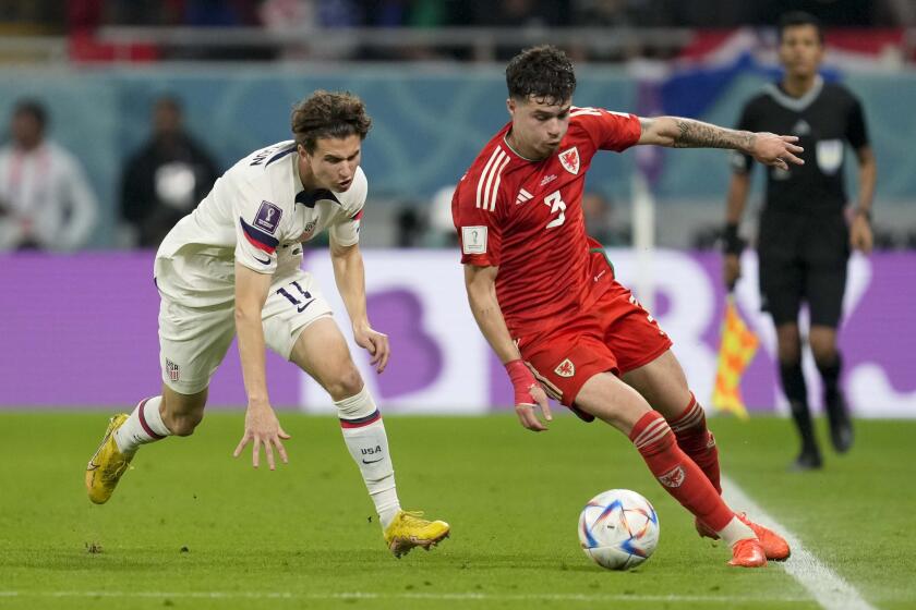 Wales' Neco Williamsand Brenden Aaronson of the United States vie for the ball during the World Cup.