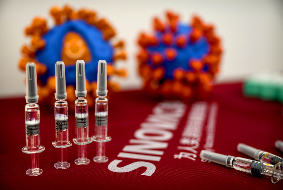 Syringes of a potential COVID-19 vaccine lie on a table.