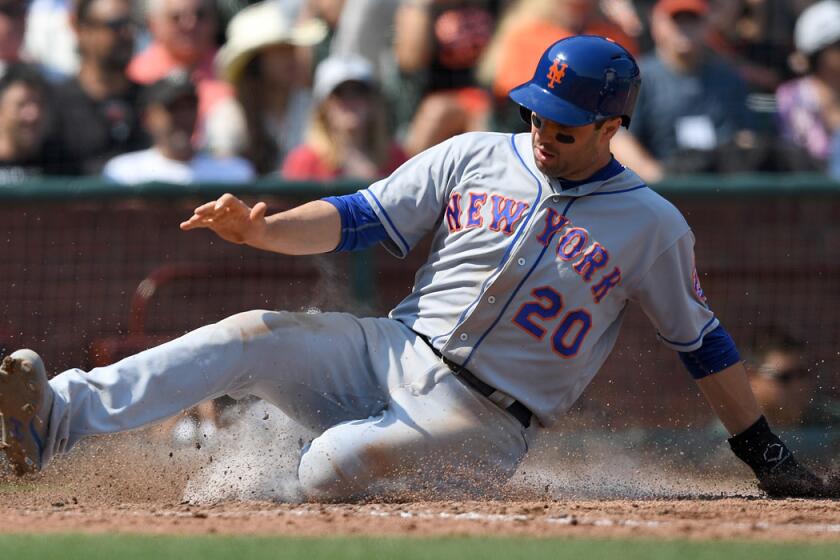 New York Mets second baseman Neil Walker slides at home scoring on an RBI single from Justin Ruggiano against the San Francisco Giants in the top of the six inning on Aug. 20.