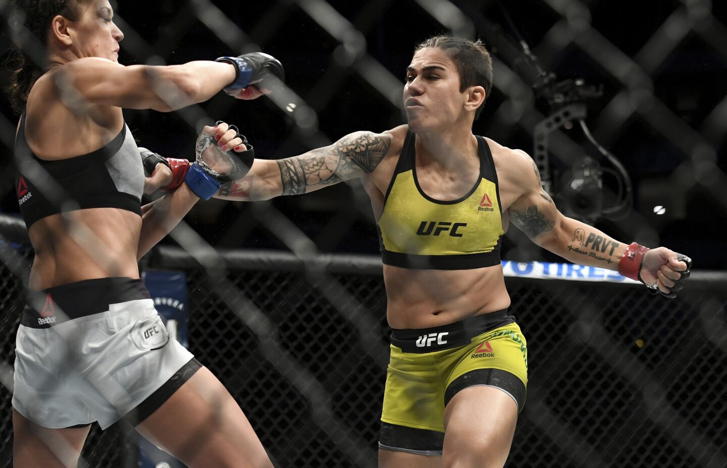 Jessica Andrade, right, winds up to punch Karolina Kowalkiewicz during their strawweight title mixed martial arts bout at UFC 228 on Saturday, Sept. 8, 2018, in Dallas. (AP Photo/Jeffrey McWhorter)