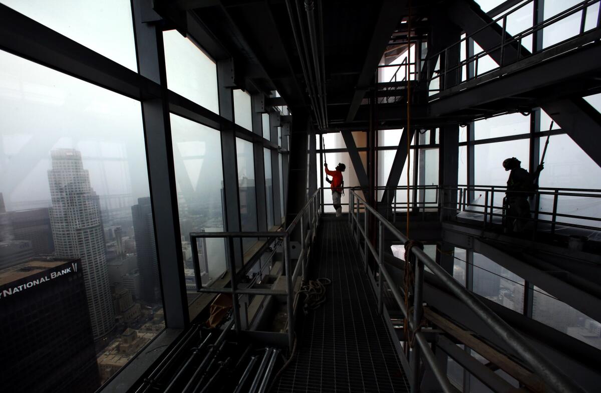 Leonel Jimenez, left, and Robert Rasmussen apply primer to steel connections inside the sail that rises above the 73rd floor.