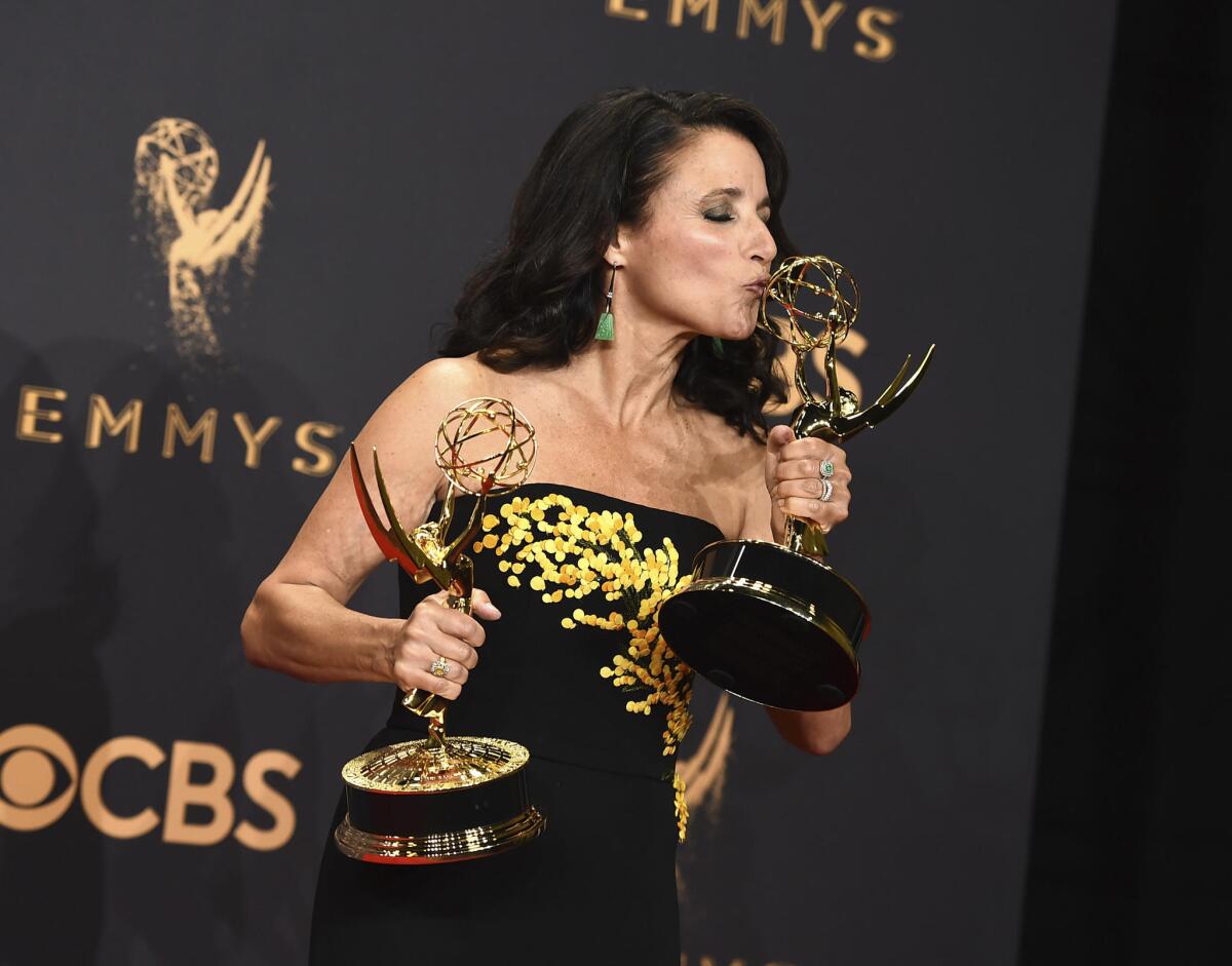 Julia Louis-Dreyfus poses in the press room with her awards for lead actress in a comedy series and omedy series for "Veep."