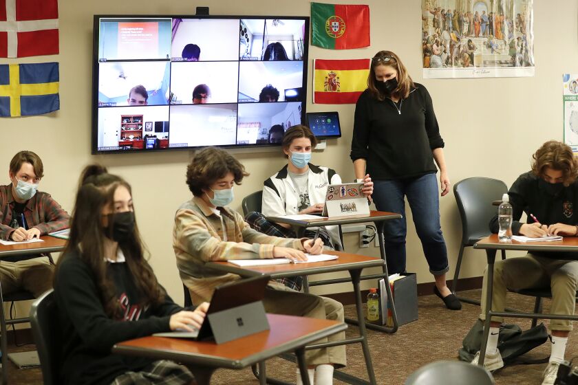 Laura Kennedy teaches her social studies class while other students follow along on a Zoom screen at JSerra Catholic High School in San Juan Capistrano.