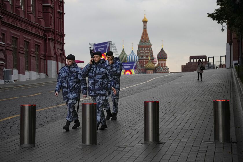 Policemen walk at Red Square with the St. Basil's Cathedral and Lenin Mausoleum in the background ahead of a planned concert in Moscow, Russia, Thursday, Sept. 29, 2022. The Kremlin said that Russian President Vladimir Putin and the leaders of the four regions of Ukraine that held a referendum on joining Russia will attend a ceremony to sign documents on the regions' incorporation into Russia, which will be followed by a big concert on Red Square. (AP Photo/Alexander Zemlianichenko)