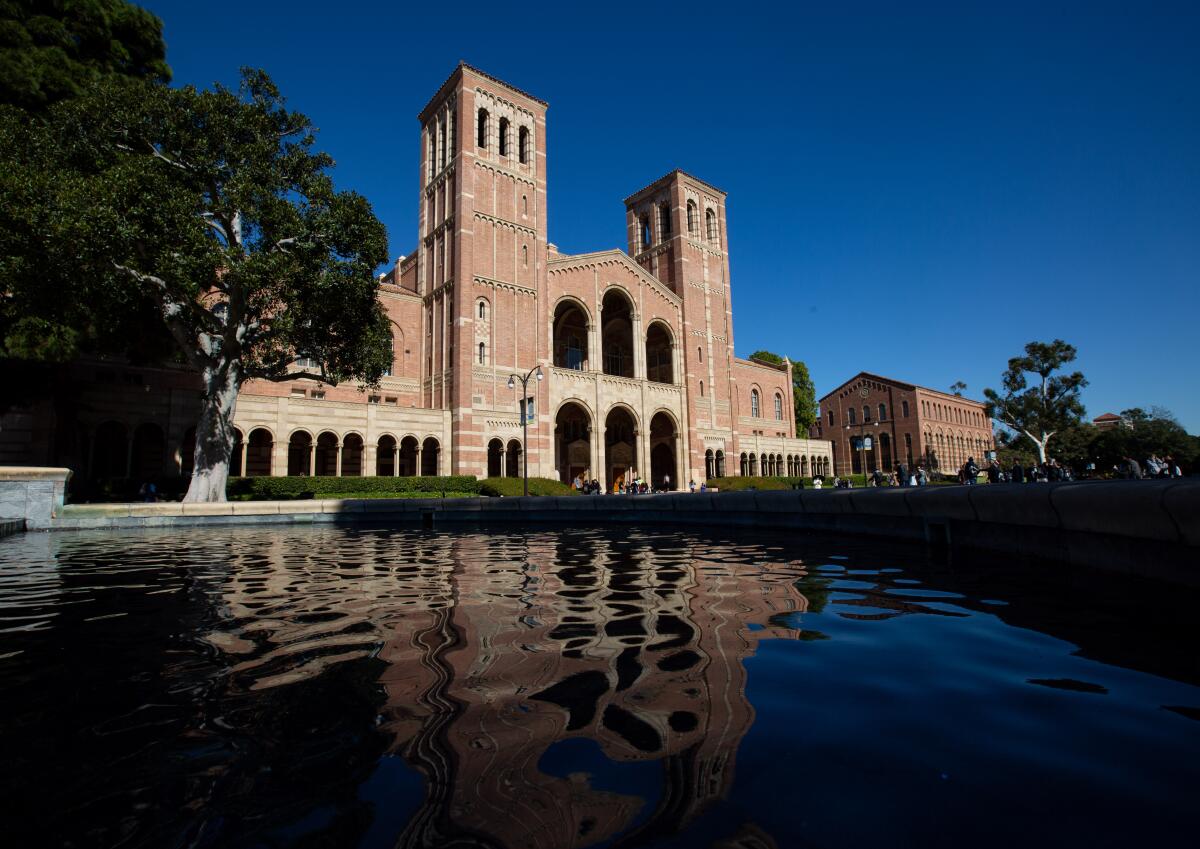 Royce Hall is reflected in a pool of water.