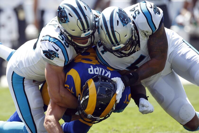 Carolina Panthers middle linebacker Luke Kuechly, left, and outside linebacker Shaq Thompson (54) tackle Los Angeles Rams wide receiver Cooper Kupp (18) during the first half an NFL football game in Charlotte, N.C., Sunday, Sept. 8, 2019. (AP Photo/Brian Blanco)