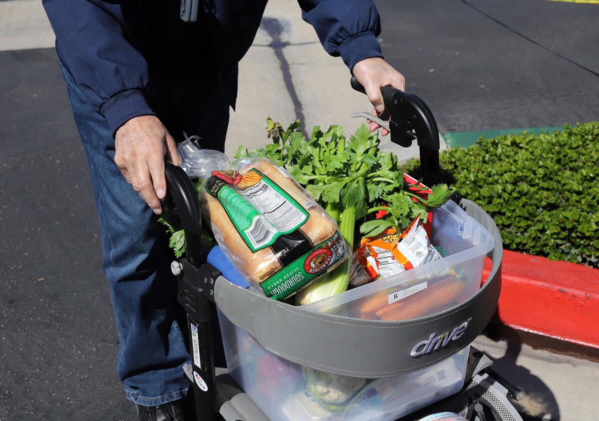 A senior stocks up on food and fresh produce from the Second Harvest Food Bank's Granny's Market on Tuesday.