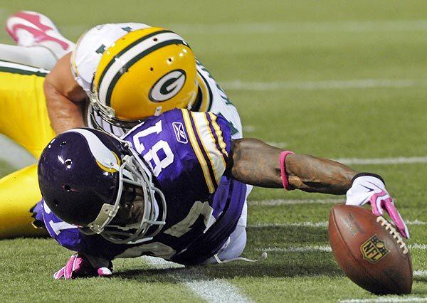 Vikings wide receiver Bernard Berrian reaches for a first down after being tackled by Packers Aaron Kampman during the first half of Minnesota's victory against Green Bay on Monday night.