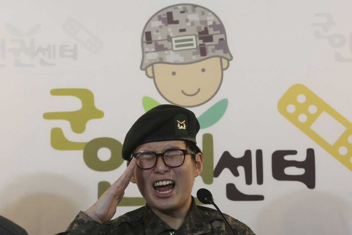 FILE - In this Jan. 22, 2020 file photo, South Korean army Sergeant Byun Hui-su salutes during a press conference at the Center for Military Human Right Korea in Seoul, South Korea. A South Korean court ruled Thursday, Oct. 7, 2021, that the military unlawfully discriminated against the country's first known transgender soldier by discharging her for undergoing gender reassignment surgery, in a landmark verdict that came seven months after she was found dead at her home. The sign reads "The Center for Military Human Right Korea." (AP Photo/Ahn Young-joon, File)