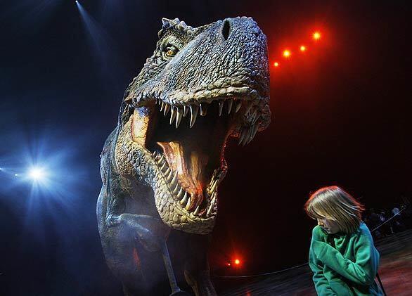 A 10-year-old girl cowers as a life-size Tyrannosaurus Rex roars in her face during a media launch of "Walking with Dinosaurs" at the O2 Arena in London. The show, based on an award-winning BBC television series, features 15 life-size dinosaurs that come to life in a presentation that tells the tale of their evolution over millions of years, through to their extinction.