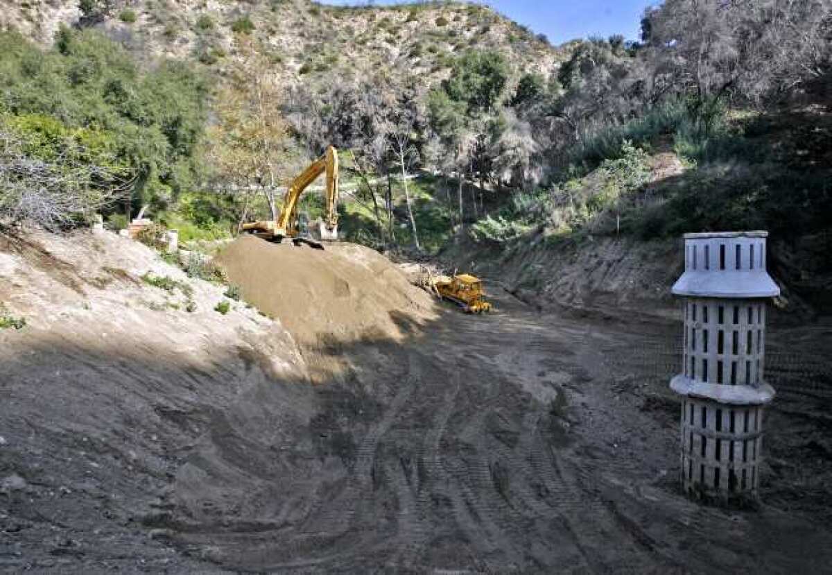 L.A. County Public Works crews remove debris from the Mullally debris basin at the end of Manistee Drive in the Paradise Valley neighborhood in La Canada Flintridge in 2010. Officials are planning a drainage tunnel from the basin to Pickens Canyon.