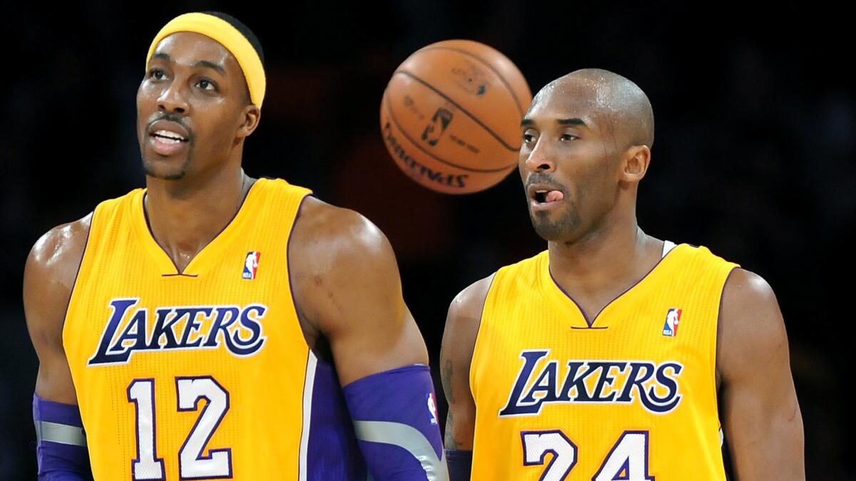Lakers teammates Dwight Howard, left, and Kobe Bryant walk off the court during a game against the Milwaukee Bucks in January 2013.