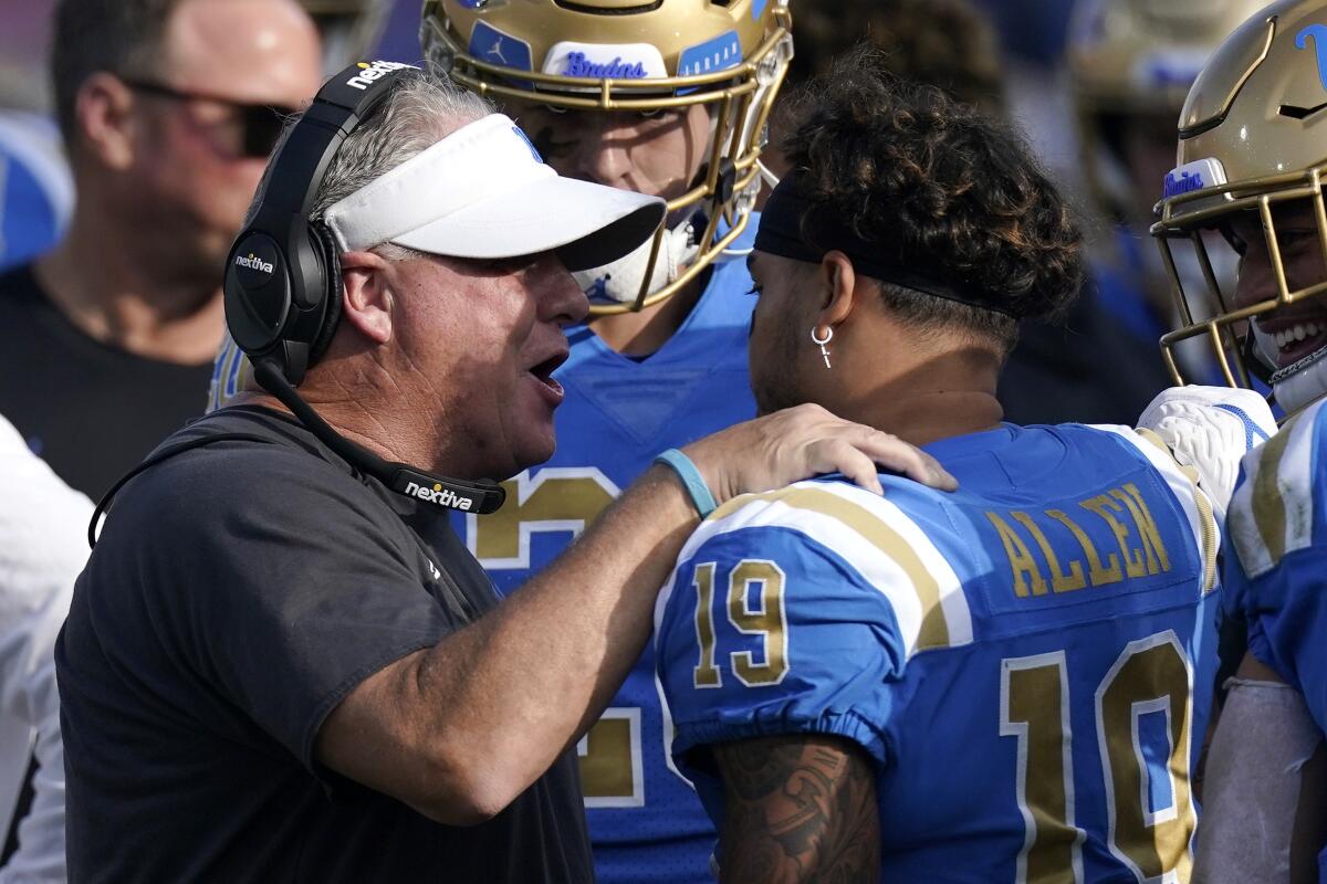 UCLA head coach Chip Kelly congratulates running back Kazmeir Allen.