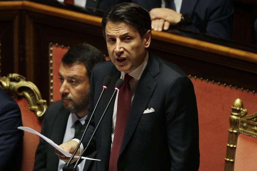 FILE - In this Tuesday, Aug. 20, 2019 file photo, Italian Premier Giuseppe Conte, right, is flanked by Deputy-Premier Matteo Salvini as he addresses the Senate in Rome. Italy's populist 5-Star Movement has asked, Wednesday, Aug. 28, 2019, the nation's president to give caretaker Premier Giuseppe Conte the mandate to form a new coalition government, a week after the one he led for 14 months collapsed. (AP Photo/Gregorio Borgia, File)